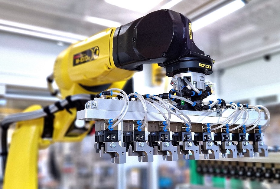 8-fach-Greifer vorne an einem gelben Roboterarm befestigt