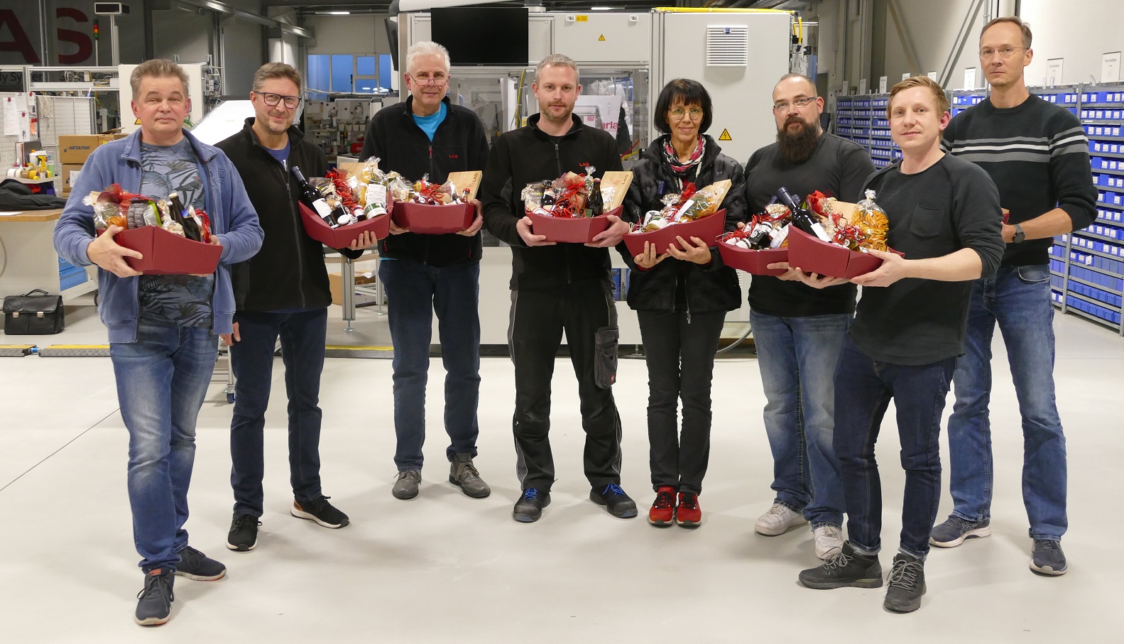 Eight LAS employees with gift baskets that they received on their 10th anniversary with the company