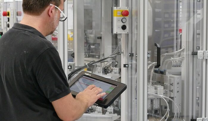 LAS employee controlling an assembly machine with a mobile panel