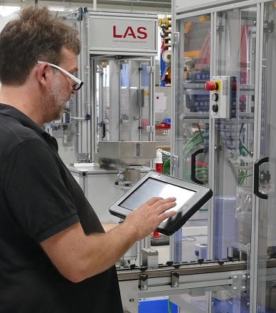 LAS employee controlling an assembly machine with a mobile panel